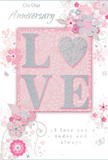 This anniversary card has the gentle intimacy of a whispered promise, ideal to slip alongside a bouquet arriving at one of Canary Wharf's riverside apartments or offices. At the centre, the word LOVE is spelled out in soft, raised glitter, each letter catching the light with a tender sparkle, while the O is lovingly replaced by a shimmering silver-textured heart. The tactile quality of the design encourages the fingertips to explore, reminiscent of brushing against velvety rose petals in a carefully arranged anniversary bouquet. Surrounding this focal point, delicate blossoms in blush pink and soft mauve open with a watercolour softness, their translucent petals layered over a pale pink background that glows like dawn light touching the dockside. Fine, flowing lines weave between the flowers, sketching out slender stems, curled leaves, and tiny flourishes that echo the artistry of a florist composing romantic arrangements for homes and businesses around Canary Wharf, Poplar, and the Isle of Dogs. Little butterflies, swirling petals, and subtle decorative curls add gentle movement, as if a light spring breeze were drifting off the Thames and stirring the design to life. Above and below the central motif, graceful script phrases such as On Our Anniversary and I love you today and always are written in elegant, understated lettering, their curves harmonising with the floral swirls. The overall composition feels soft yet significant, like a treasured keepsake that will be tucked into a drawer long after the fresh flowers have faded. It perfectly captures the feeling of celebrating an enduring love story in the heart of the city, while still making space for quiet, private emotion.